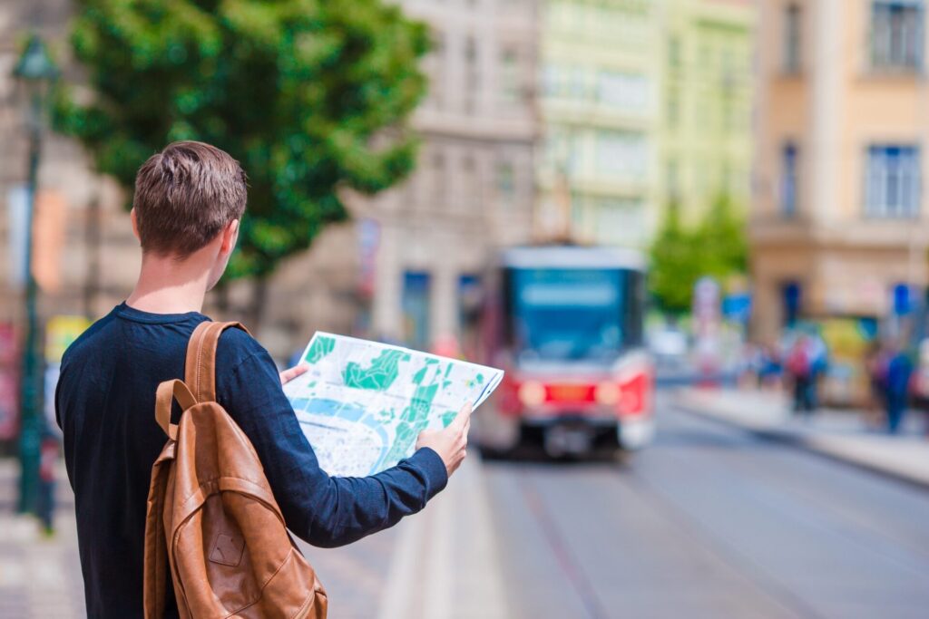 Man tourist with a citymap waiting the train in european city